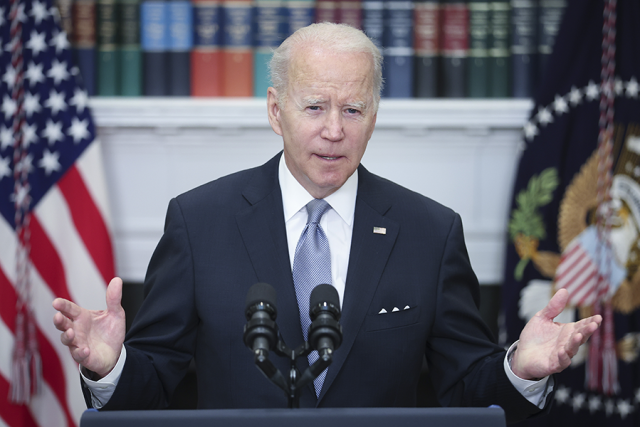President Joe Biden signs a document approving military aid for Ukraine at the White House.