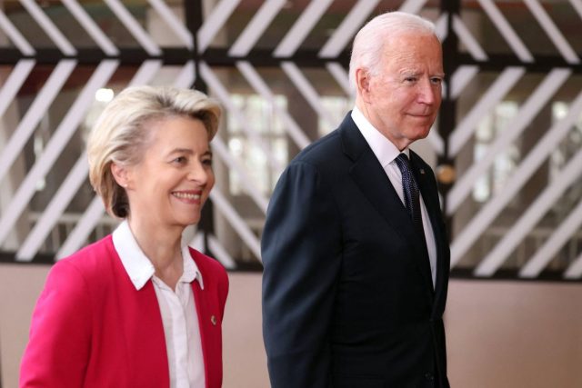 Biden and Von der Leyen shake hands at podium beside US and EU flags after announcing LNG supply agreement.