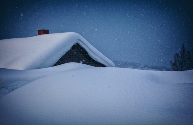 Snow-covered rooftops in a rural Afghan village after a heavy snowstorm caused structural damage and highway closures.