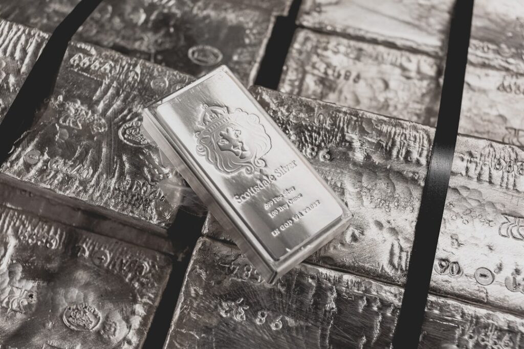 Stack of silver bullion bars reflecting light on a dark surface