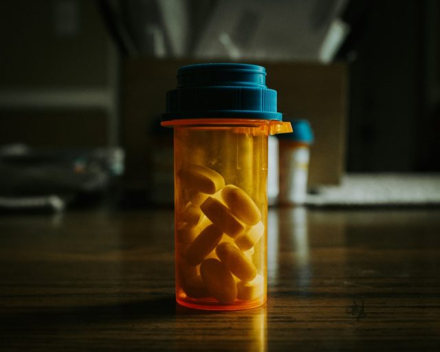 Close-up of blister-pack Paxlovid tablets on a kitchen counter beside a positive COVID test.