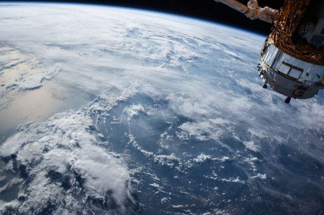 Russian Progress freighter docked to the Zvezda module fires thrusters to boost the International Space Station's altitude in orbit.
