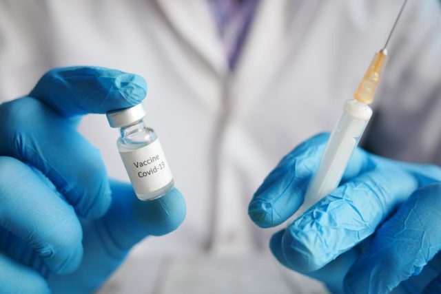 A syringe and vial labeled CoronaVac sit on a table, representing the vaccine targeted by a US military disinformation effort.