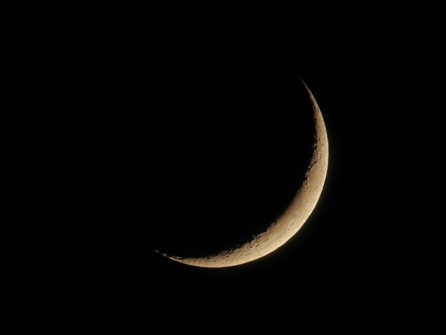 Earth's shadow creeps across the moon during a partial lunar eclipse, turning part of the lunar surface a coppery grey.