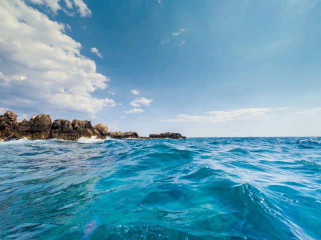 A capsized wooden boat floats in rough Mediterranean waters off the Tunisian coast near Sfax.
