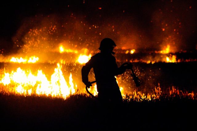 Firefighters and locals survey a destroyed shop in Muang Xai, Oudomxay province, after a deadly explosion and fire.