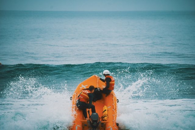 Rescuers pull a body from the Mediterranean Sea near Lampedusa's rocky coast after a migrant boat capsized.