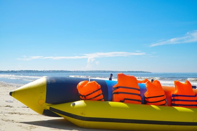 Turkish Coast Guard crew pulls a body from the Aegean Sea near Bodrum, with a capsized inflatable boat in the background.
