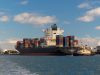Iran General Threatens to Close Red Sea Shipping A cargo ship navigates the narrow Bab el-Mandeb strait, with military vessels visible on the horizon.