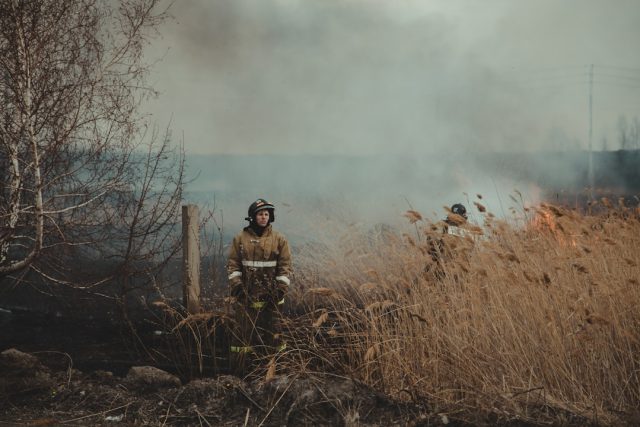 Firefighters inspect a leveled home site after a propane blast in rural Pennsylvania, with debris scattered across the property.