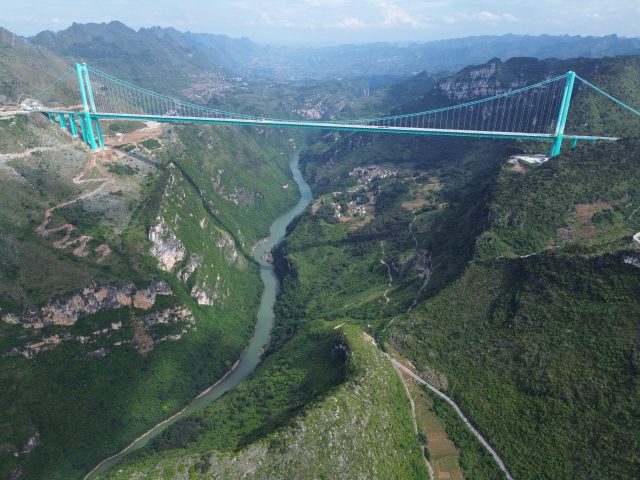 Alpine suspension bridge soars 625 meters above a misty Guizhou canyon as the first cars cross the new record-setting span.