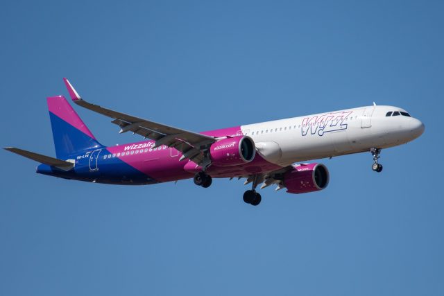 An Airbus A321neo on a runway at Denver International Airport with emergency vehicles nearby after an aborted takeoff.