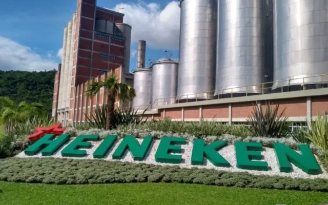 Heineken brewery exterior in Ponta Grossa, Brazil, with construction equipment and workers preparing for expansion.