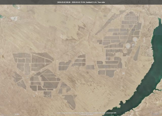 Aerial view of the Talatan Solar Park's vast array of solar panels stretching across the Tibetan Plateau in Qinghai Province, China.