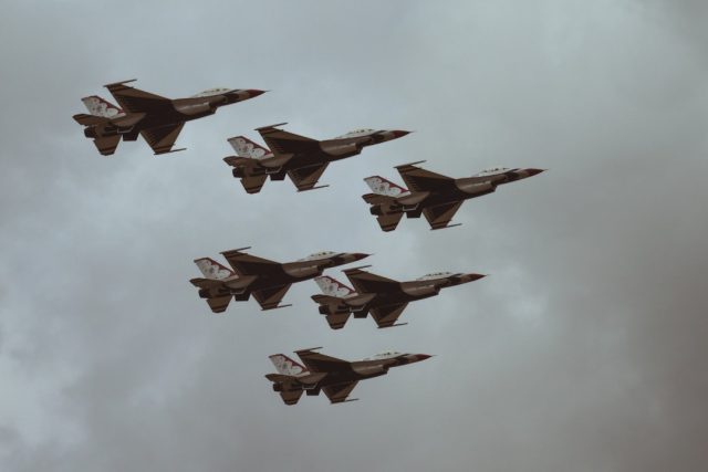 Taiwanese fighter jets scramble on a runway as military personnel prepare for rapid response to Chinese aircraft crossing the median line.