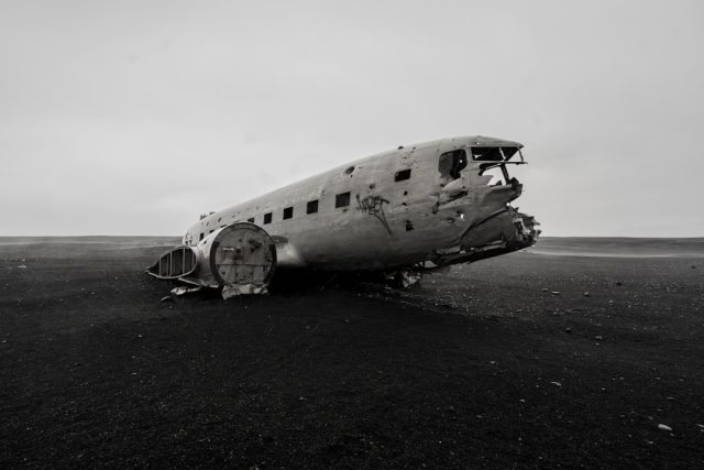 Investigators examine wreckage of a small Cessna plane scattered across a remote, rugged landscape in eastern Iceland.