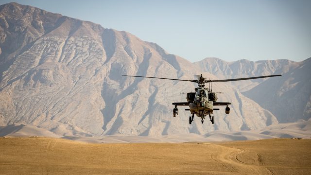 A helicopter approaches a radio tower in a dense urban skyline, illustrating the risks of low-altitude flight.