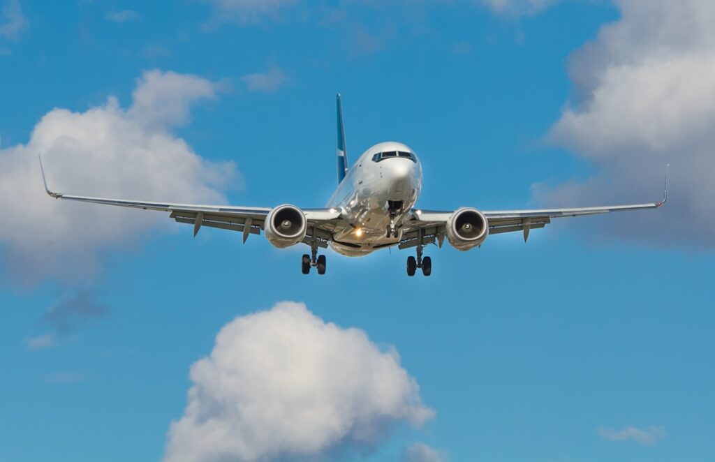 A Flybe regional aircraft parked at a British airport terminal with passengers boarding nearby.