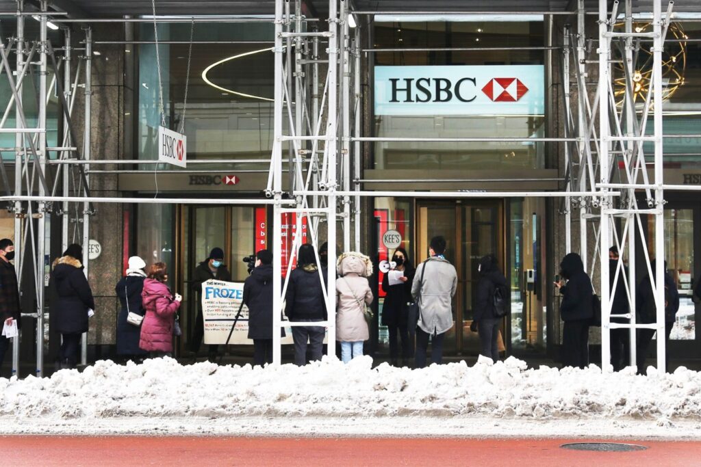 HSBC bank building exterior with Hong Kong skyline in background, symbolizing corporate compliance controversy