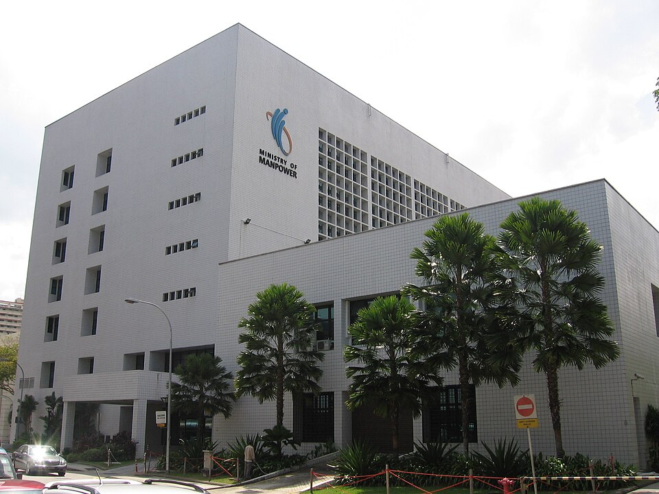 Singapore's Ministry of Manpower building exterior with workers entering and exiting during the COVID-19 pandemic