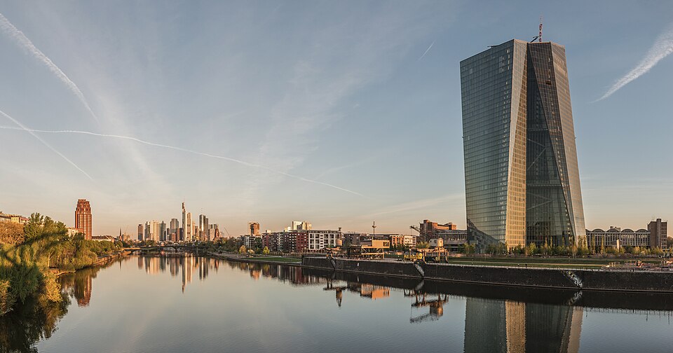 European Central Bank headquarters in Frankfurt, with euro currency symbols visible on the building facade.